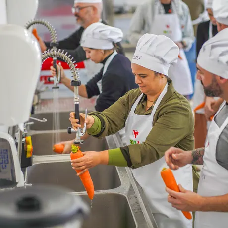 Participantes lavando legumes na cozinha