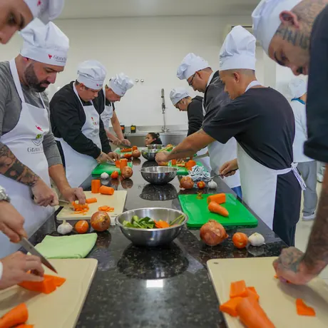 Participantes cortando legumes na bancada